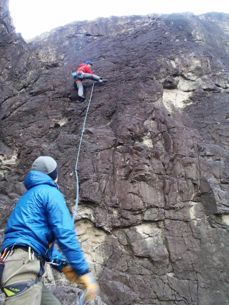 トップロープのビレイをしていただくために登っていく井坂ガイド。