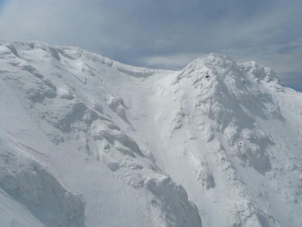 富良野岳北壁。ルンゼのエントリーは中央雪庇の右端。雪庇の左端が頂上。