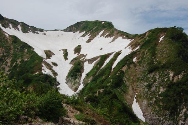 雪渓の右の尾根を歩き、雪渓の上にある五竜山荘を目指します。